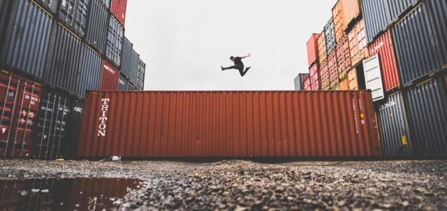 Mann spring über Transportcontainer